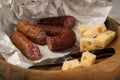 Ring Salami pork sausage with German BierbeiÃÅ¸er and Edamer cheese in wax paper with knife on wooden board background for Brotzeit